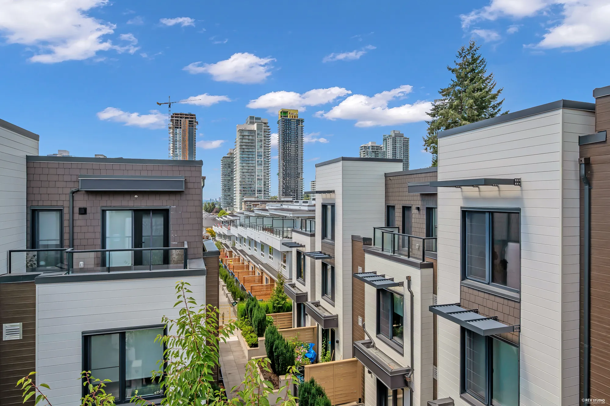 From the balcony down the row of townhomes and their patios, towers beyond