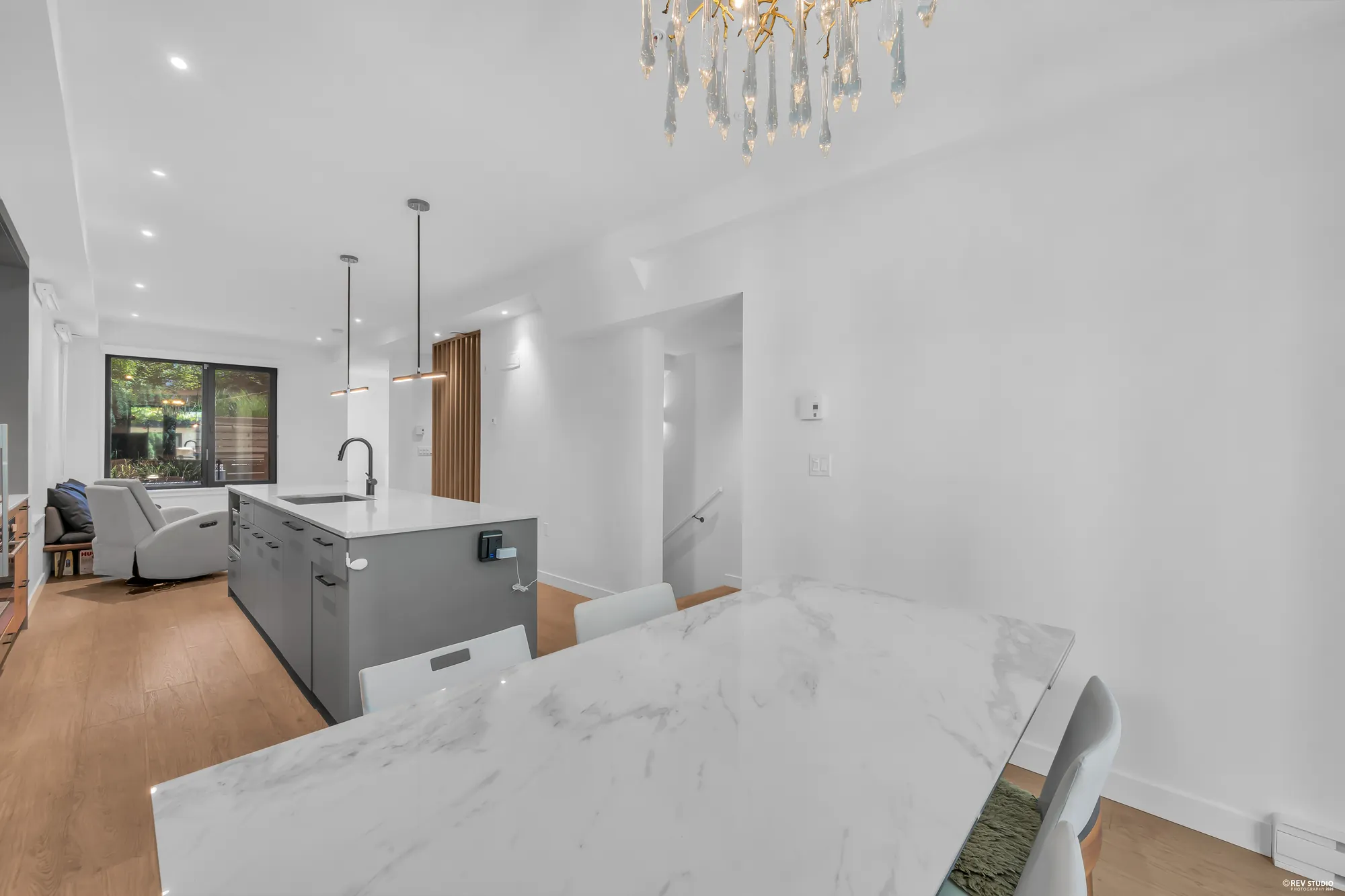 From the dining table across the kitchen island to the living room and its front window